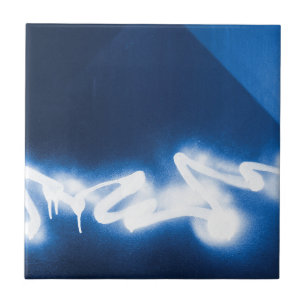 Sprayed graffiti on blue metal tile