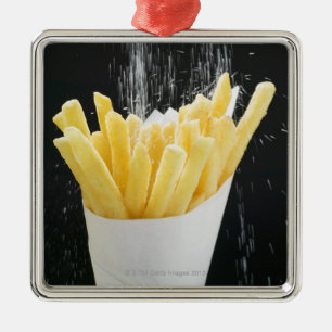 Sprinkling salt on chips in paper cone metal ornament