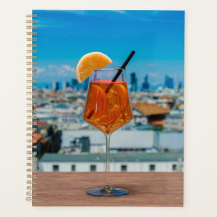 Spritz cocktail on a table with view of Milan Planner