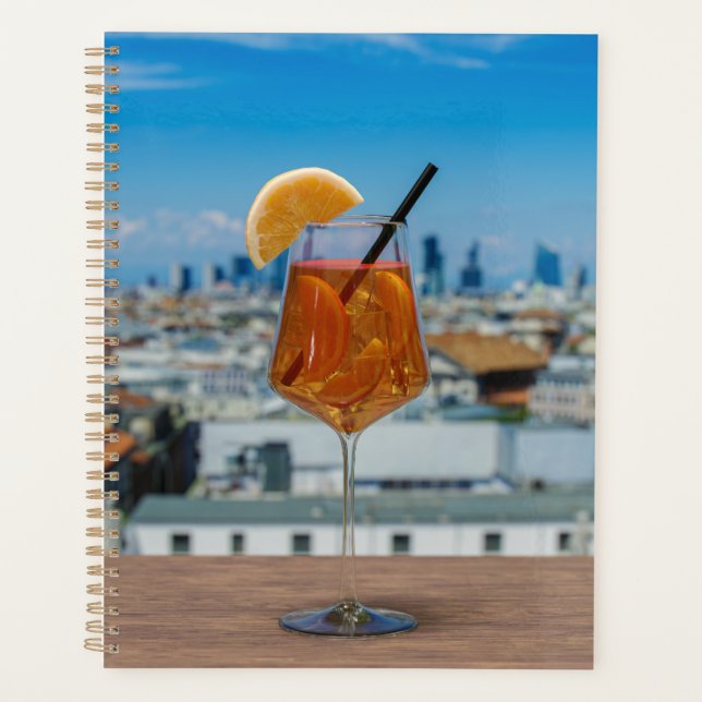 Spritz cocktail on a table with view of Milan Planner (Front)