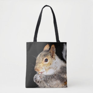 Squirrel eating a nut tote bag