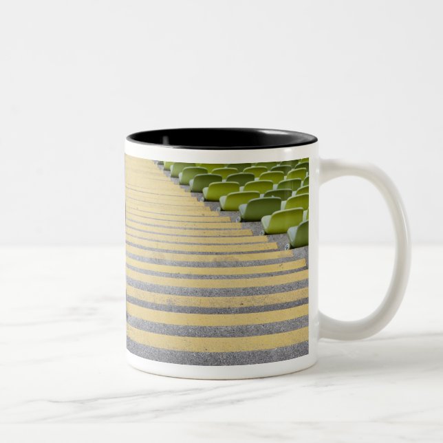 Stadium stairway between rows of green seats Two-Tone coffee mug (Right)