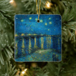 Starry Night Over the Rhône | Vincent van Gogh Ceramic Ornament<br><div class="desc">Starry Night Over the Rhône (1888) by Vincent van Gogh is a mesmerizing Post-Impressionist painting that captures a serene nighttime view of the Rhône River in Arles, France. The artwork features a deep blue sky adorned with shimmering golden stars and their reflections on the water. In the foreground, two figures...</div>