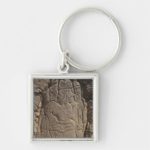 Stela depicting a warrior holding a club keychain