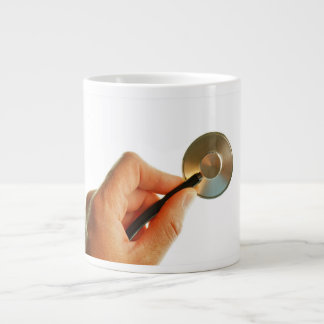 Stethoscope in a hand for a hospital atmosphere. large coffee mug