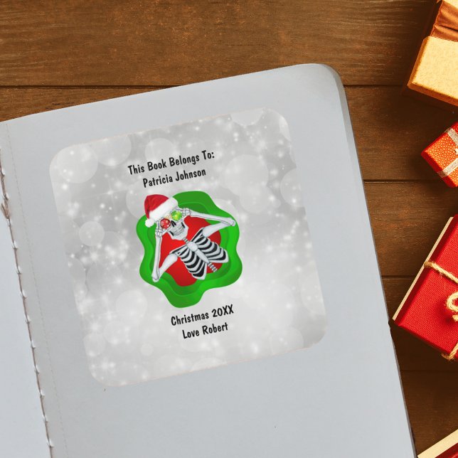 Sticker Carré Décorations squelette de Noël Rouge Vert Clair  (Cute Skeleton holding ornaments for eyes Santa Hat in green Red splatter on white book plate sticker)