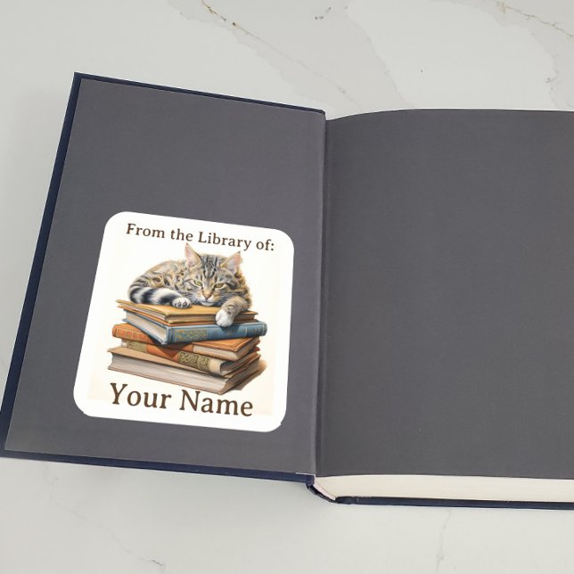 Sticker Carré Plaque avec chat sur livres (A bookplate showing a cat lying on some books is displayed inside a book.)