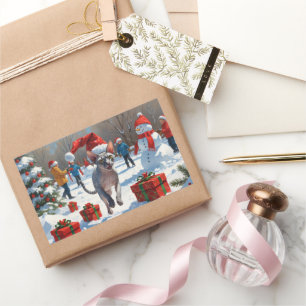 Sticker Rectangulaire Chat Sphynx courant dans la neige avec un chapeau