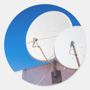 Sticker Rond Deux antennes paraboliques blanches sur le mur de