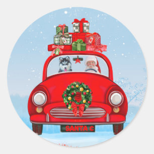 Sticker Rond Husky sibérien dans une voiture avec le Père Noël