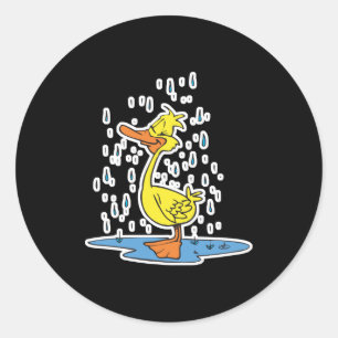 Sticker Rond joli petit canard dans une flaque sous la pluie