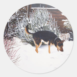 Sticker Rond Winter snow scene with cute black and tan dog