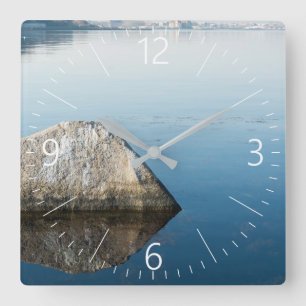 Stone and its reflection at sea surface square wall clock