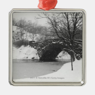 Stone bridge over snow covered river metal ornament