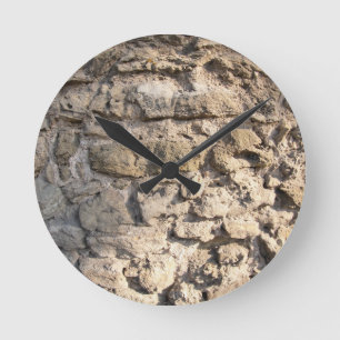 Stone wall of the large rough stones grey round clock