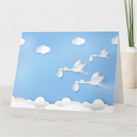 Stork flying with baby on sky greeting card