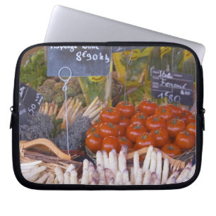Street market merchant's stall with white laptop sleeve