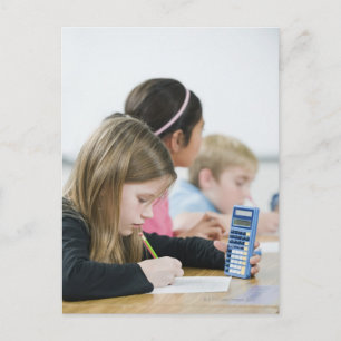 Students doing math work in classroom postcard