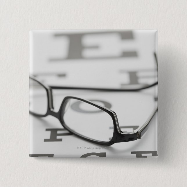 Studio shot of eyeglasses on eye chart 2 inch square button (Front)