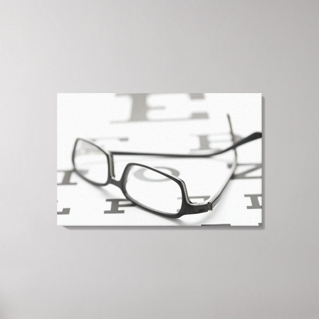 Studio shot of eyeglasses on eye chart canvas print (Front)