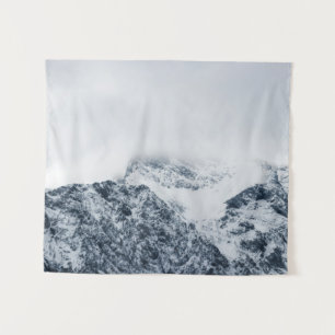 Stunning snowy mountains covered by clouds tapestry