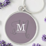 Stylish Calligraphy Monogram and Name Purple Keychain<br><div class="desc">A beautiful feminine keychain with an elegant stylish name and monogram with classic serifs and a more ornate script calligraphy in a balanced and beautiful layout. The three elements blend together with a sophisticated harmony and create your own personal branding logo. Shown here with a trendy dusty purple background with...</div>