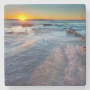 Sun rays illuminate the Pacific Ocean Stone Coaster