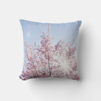 sun rays pass through pink flowers of a wow tree throw pillow