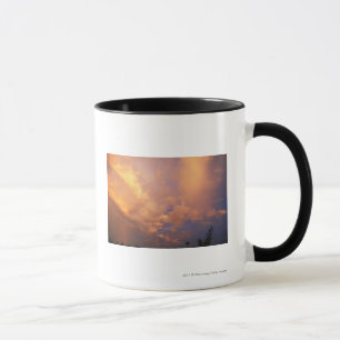 Sun setting behind clouds mug