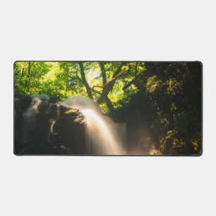 Sun shining on a magical waterfall desk mat