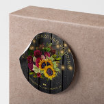 Sunflowers and burgundy roses rustic wood wedding classic round sticker<br><div class="desc">Editable text wedding favour sticker featuring a rustic big beautiful yellow sunflowers and red burgundy roses bouquet and faux gold typography script on a dark brown barn wood background with string lights. Ideal for your summer or autumn fall | elegant rustic country | outdoor backyard vintage traditional themed weddings. Personalize...</div>