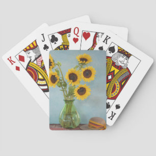 Sunflowers in vase on table playing cards