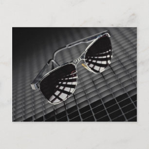 Sunglasses on grid background postcard
