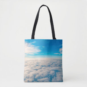 Sunrise above clouds from airplane window tote bag