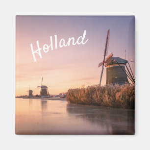 Sunrise over frozen river with windmills and reeds magnet