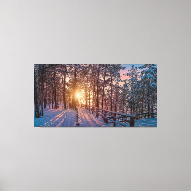 Sunset in snowy pine forest with sun ray canvas print (Front)