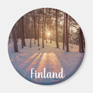 Sunset in snowy winter pine forest magnet