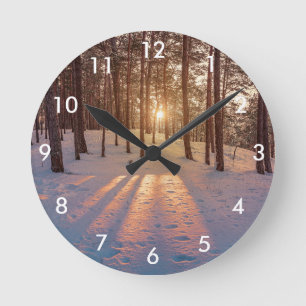 Sunset in snowy winter pine forest round clock