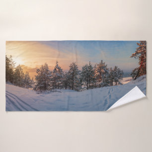 Sunset over frozen snowy forest near sea bath towel