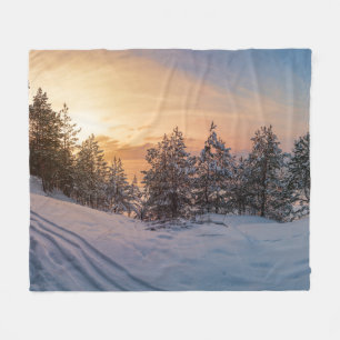 Sunset over frozen snowy forest near sea fleece blanket