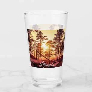 Sunset over wooden path in pine forest glass