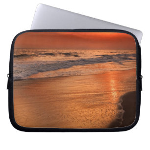 Sunset reflections off clouds and ocean shore laptop sleeve
