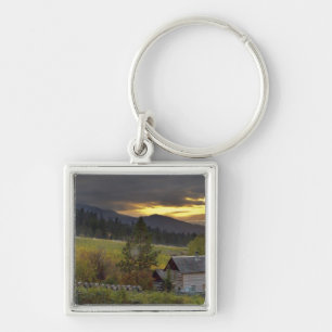 Sunset sky over vineyards and historic log cabin keychain