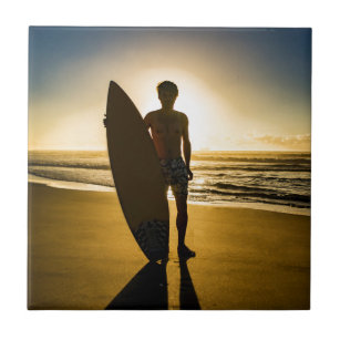 Surfer silhouette during sunrise tile