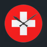 switzerland flag round clock<br><div class="desc">The flag of Switzerland (German: Schweizerfahne; French: drapeau de la Suisse; Italian: bandiera svizzera; Romansh: bandiera de la Svizra) displays a white cross in the center of a square red field. The white cross is known as the Swiss cross.</div>