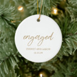 Sydney Gold First Christmas Engaged Modern Ceramic Ornament<br><div class="desc">Modern Christmas ornament featuring a contemporary typographic design with "engaged" in elegant script typography along with your names and engagement date in a simple and minimal layout. The back has your favourite photo. The colour theme is gold and white and may be changed the design editing tool. This minimalist style...</div>