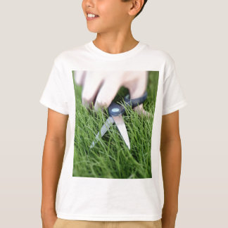 T-shirt Couper l'herbe avec une paire de ciseaux