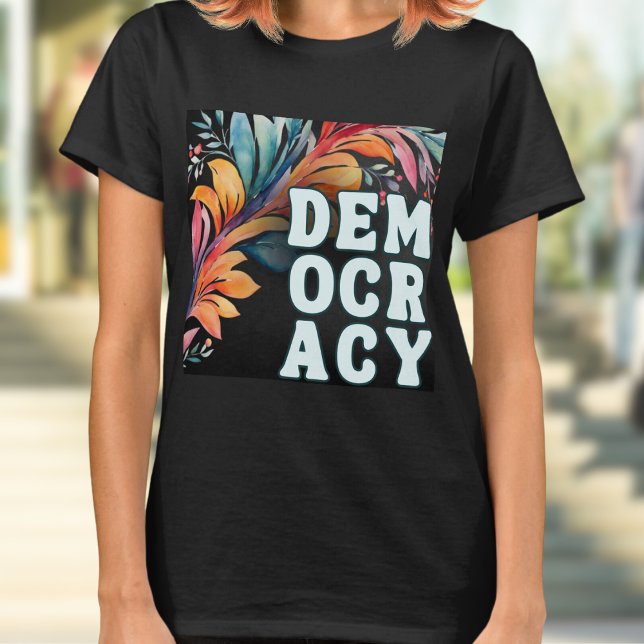 T-shirt Démocratie Déclaration Colorée Groovy Rétro (A t-shirt with 'Democracy' in capital letters in a retro groovy style, on a colorful leafy backdrop)
