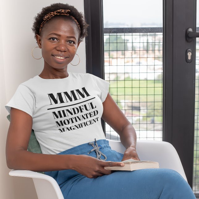 T-shirt MMM- Minutieux, Motivé, Magnifique (Young black woman wearing a "MMM:Mindful, Motivated, Magnificient" white t-shirt.)