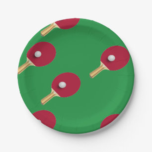 Table tennis racket and ball on green paper plate